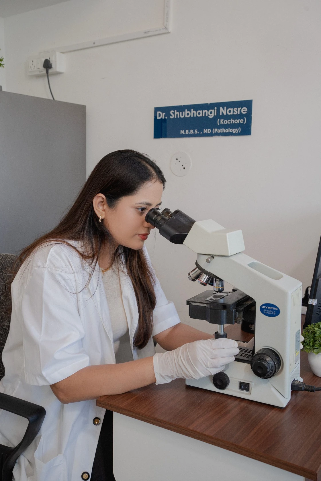 Pathologist examining a sample under a microscope
